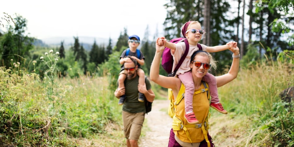 Parents and two kids hiking during the
    summer.