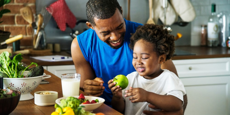 A dad and child with healthy food choices in front of them.