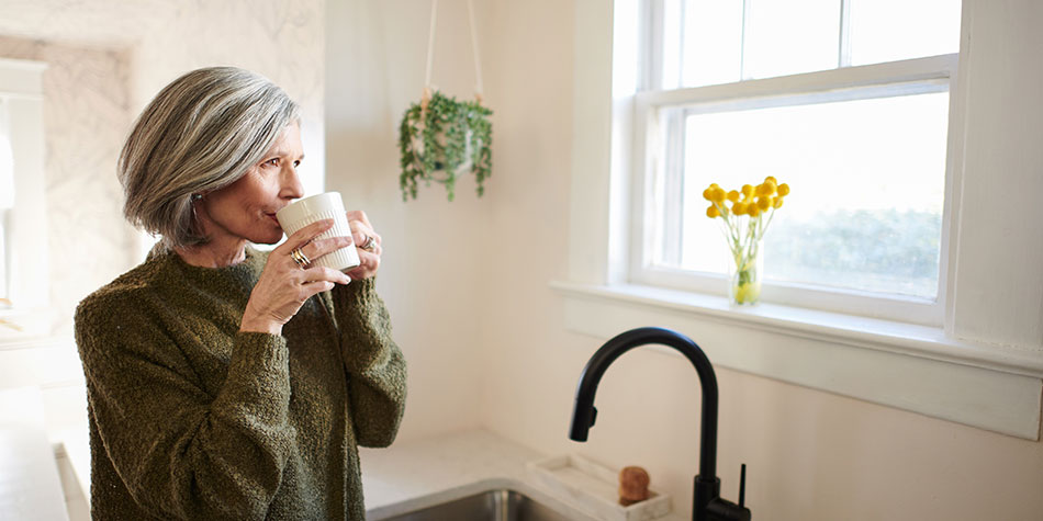 Woman drinking coffee in a kitchen